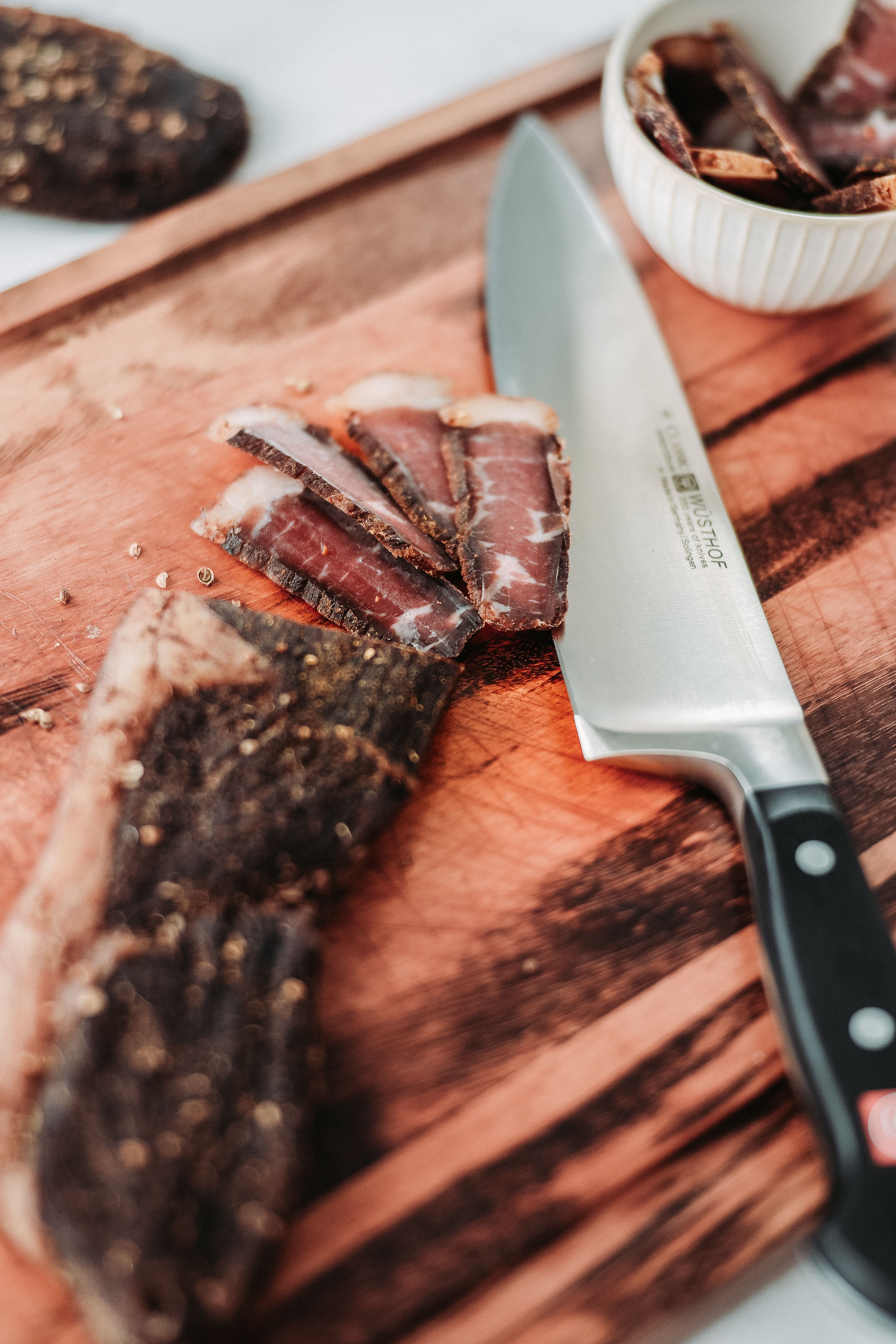 Cecina curada en rebanadas finas sobre tabla de madera