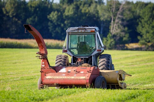 Red and Black Tractor on Green Grass Field
