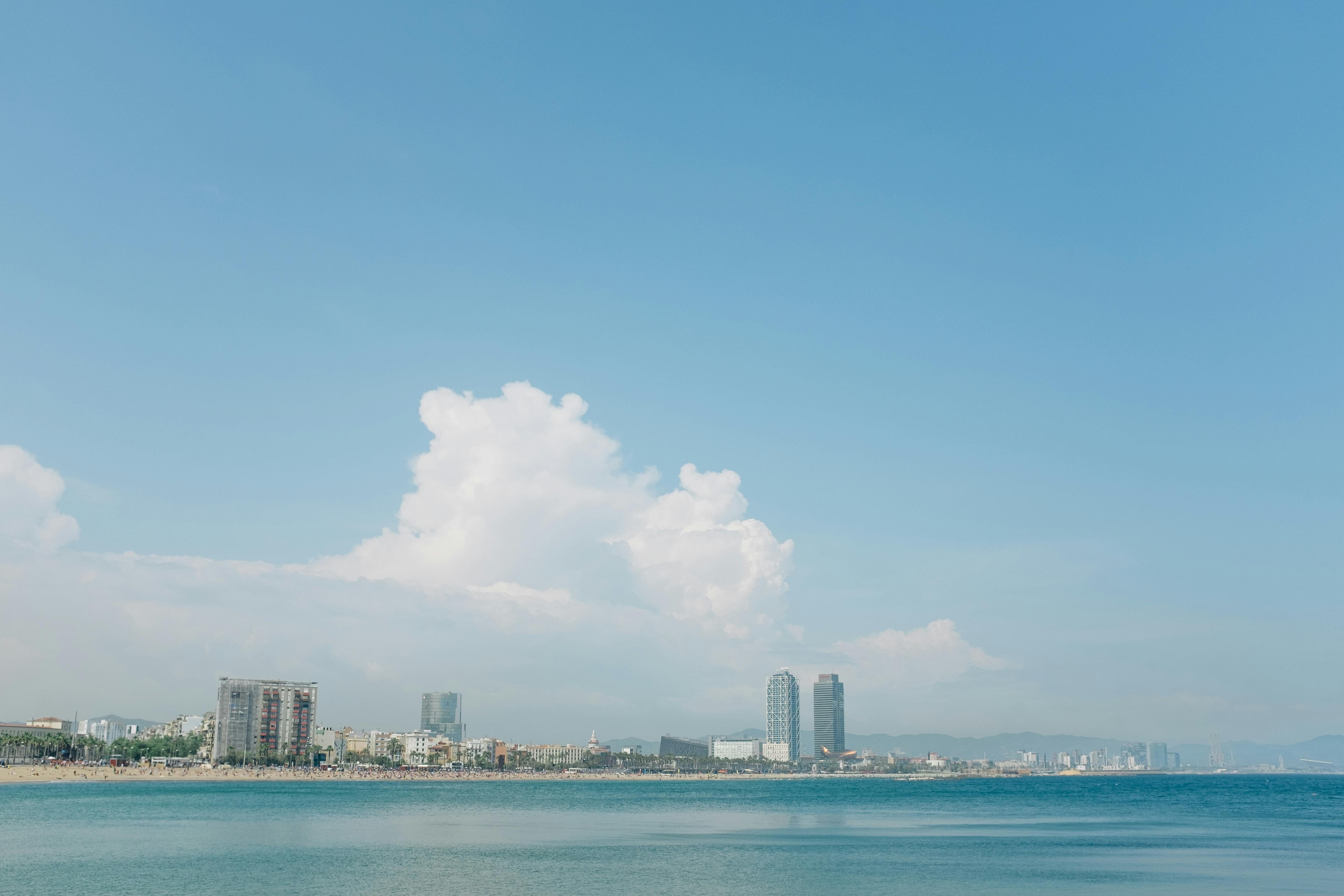 阳光明媚的日子里，沿着宁静的海滩，可以看见城市天际线的广角视图