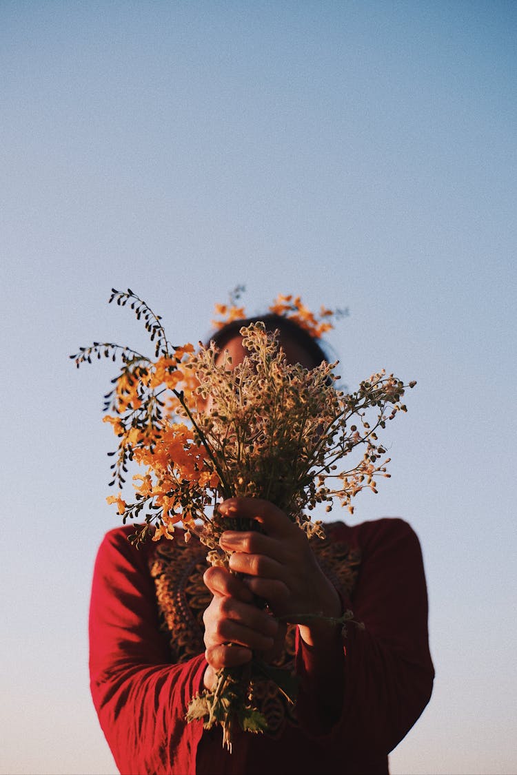 Anonymous Woman Covering Face With Dry Plants