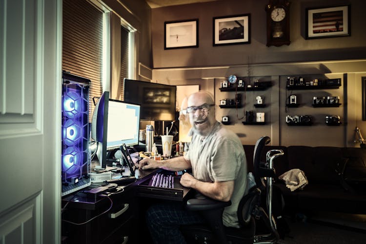 Exhausted Bearded Male Freelancer Working At Home Using Various Devices