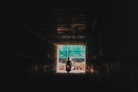 Person Riding a Motorcycle Going out from the Tunnel