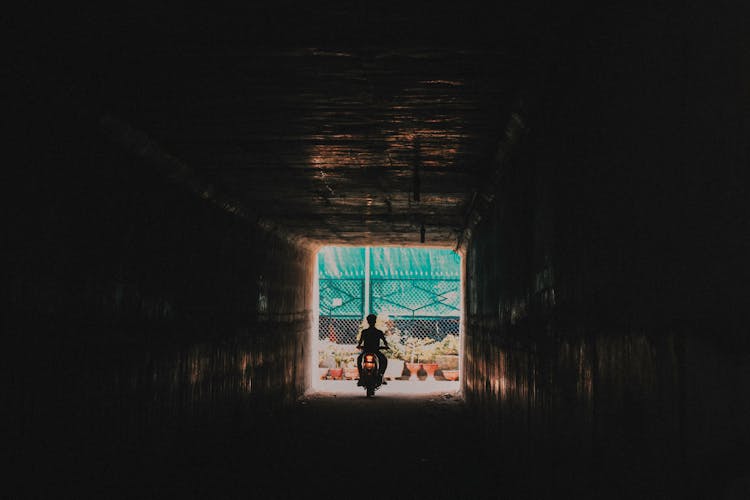 Person Riding A Motorcycle Going Out From The Tunnel