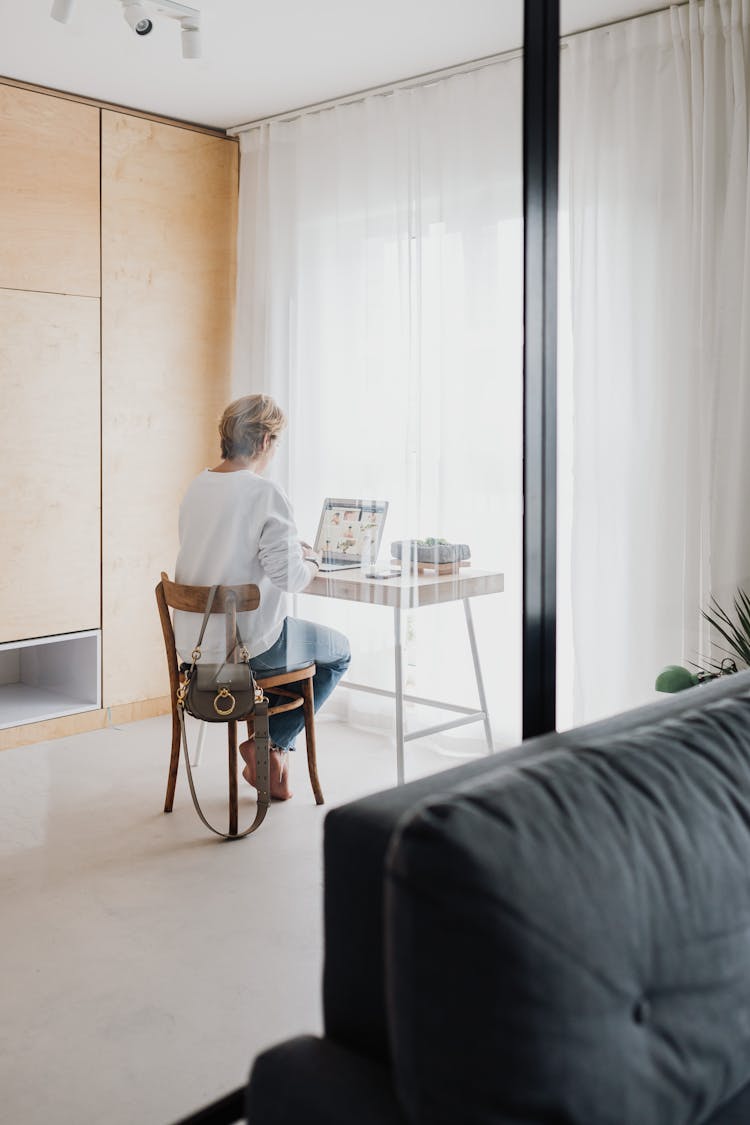 Back View Of A Person Sitting On A Wooden Chair