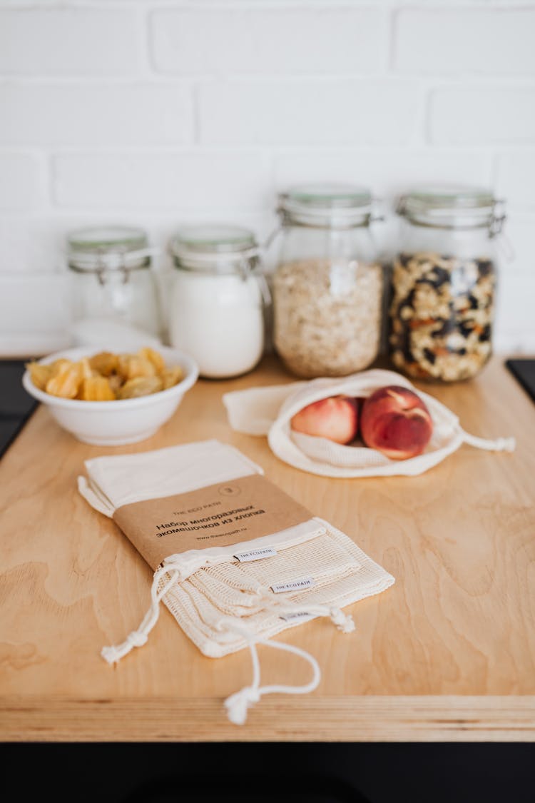 Clear Glass Jars And Reusable Bags On Wooden Surface 