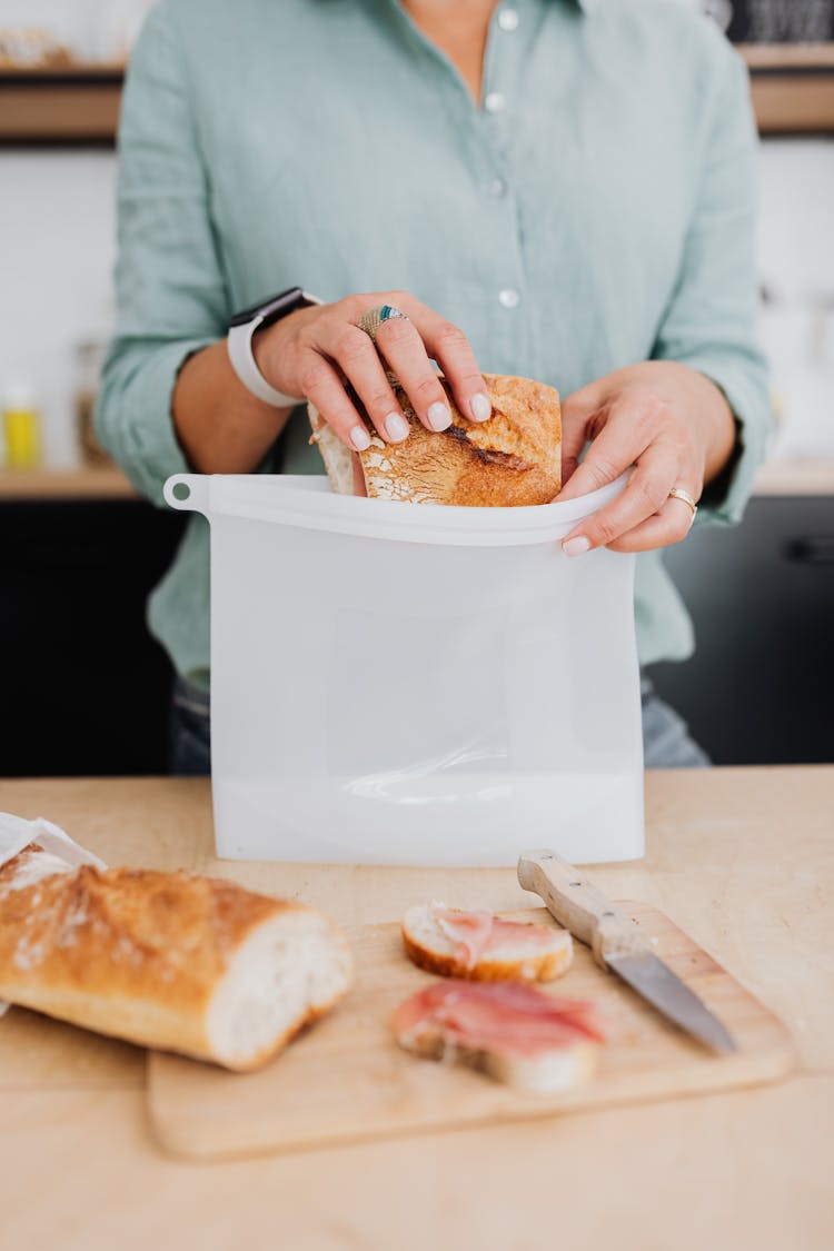 A Person Putting A Bread Inside The Silicone Pouch