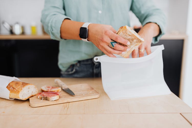 A Person Packing A Sandwich In A White Silicone Bag