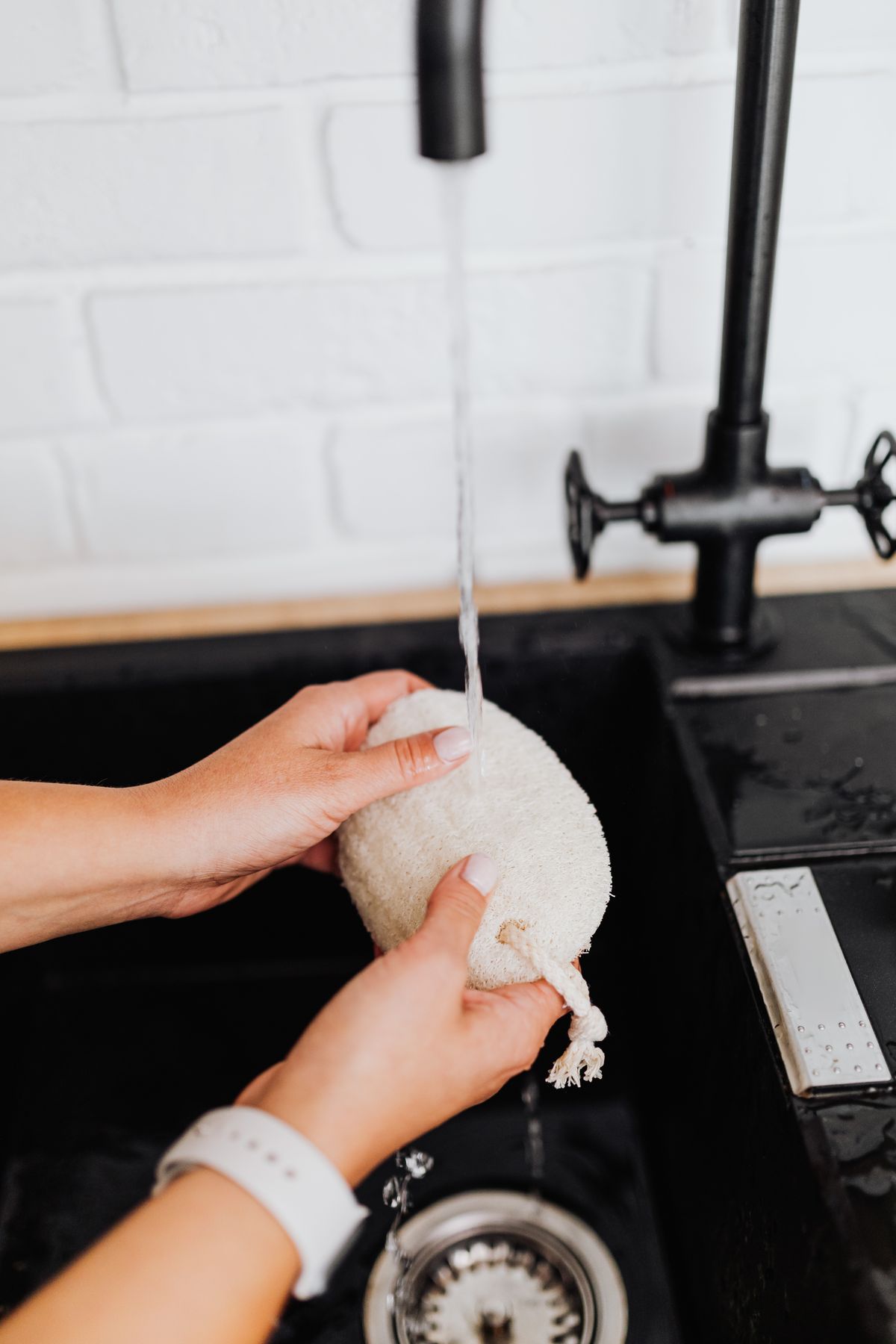 Silicone dish scrubbers rinsing under running water in a modern kitchen sink