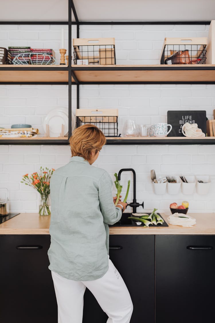 Woman Washing Leek In Kitchen Sink 