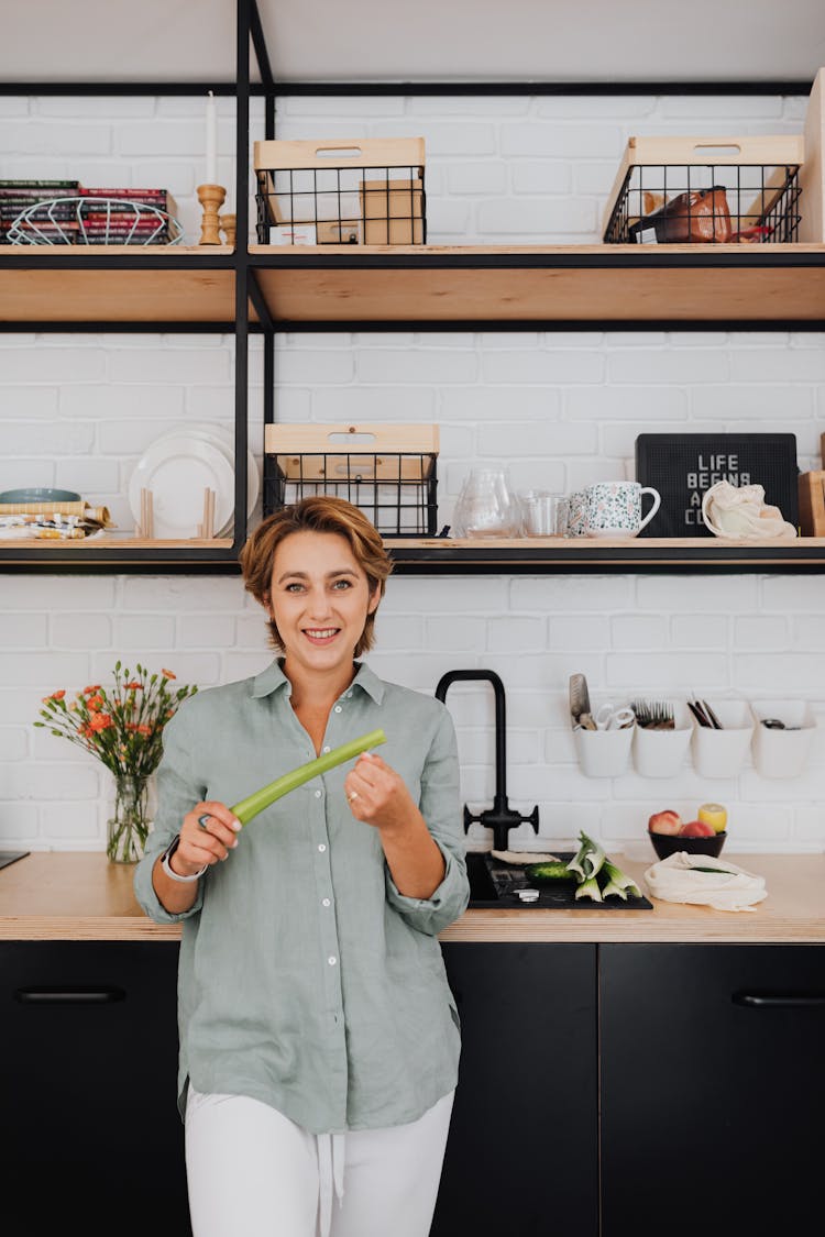 Portrait Of Smiling Woman With Vegetables In Modern Kitchen