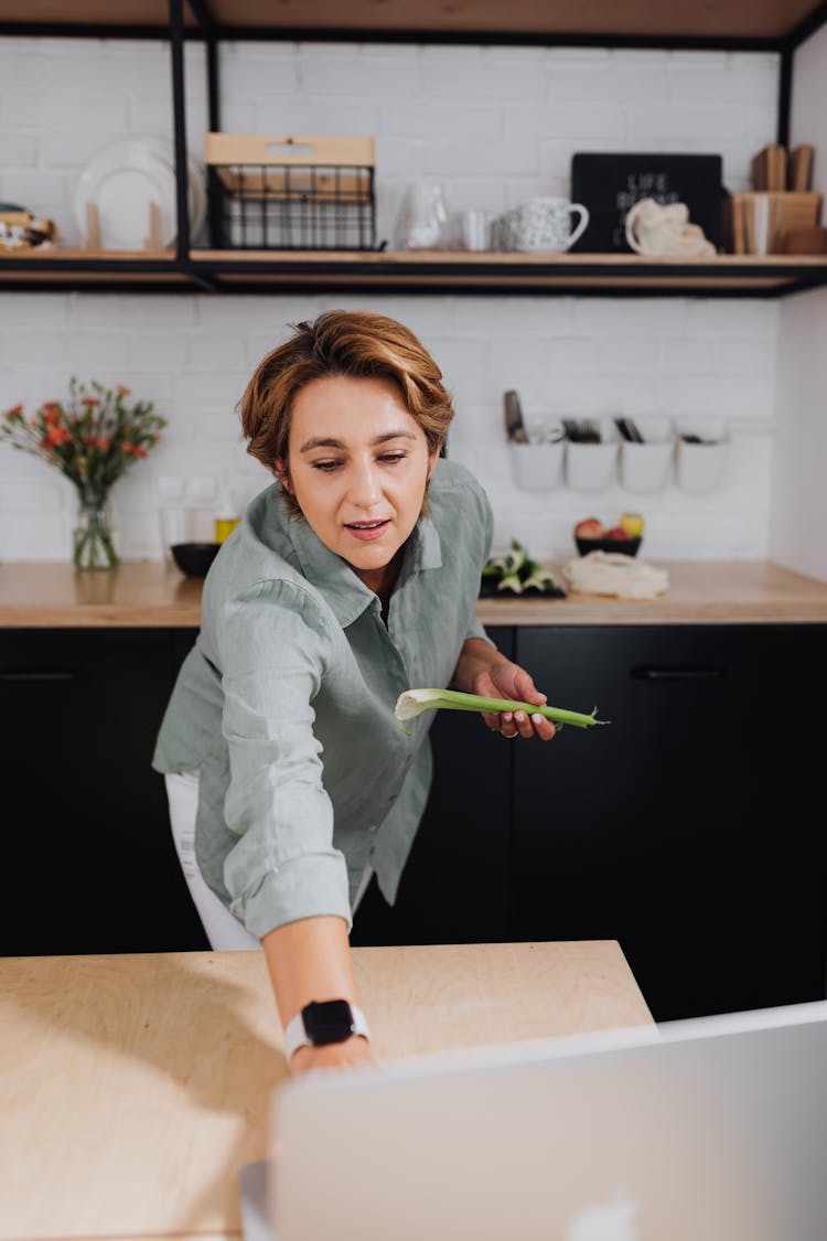 Woman Cooking With Use Of Laptop