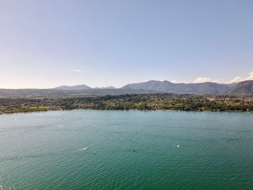 Free Aerial view of nautical transport on rippled ocean near mountains with trees under blue cloudy sky in evening Stock Photo