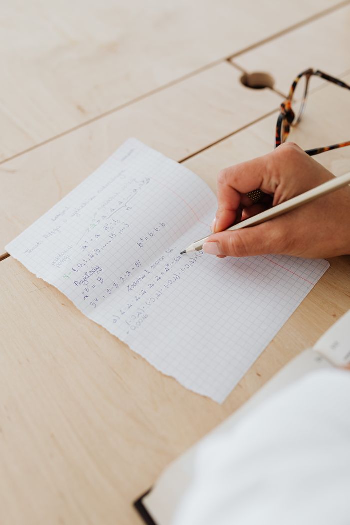 Student writing equations on graph paper