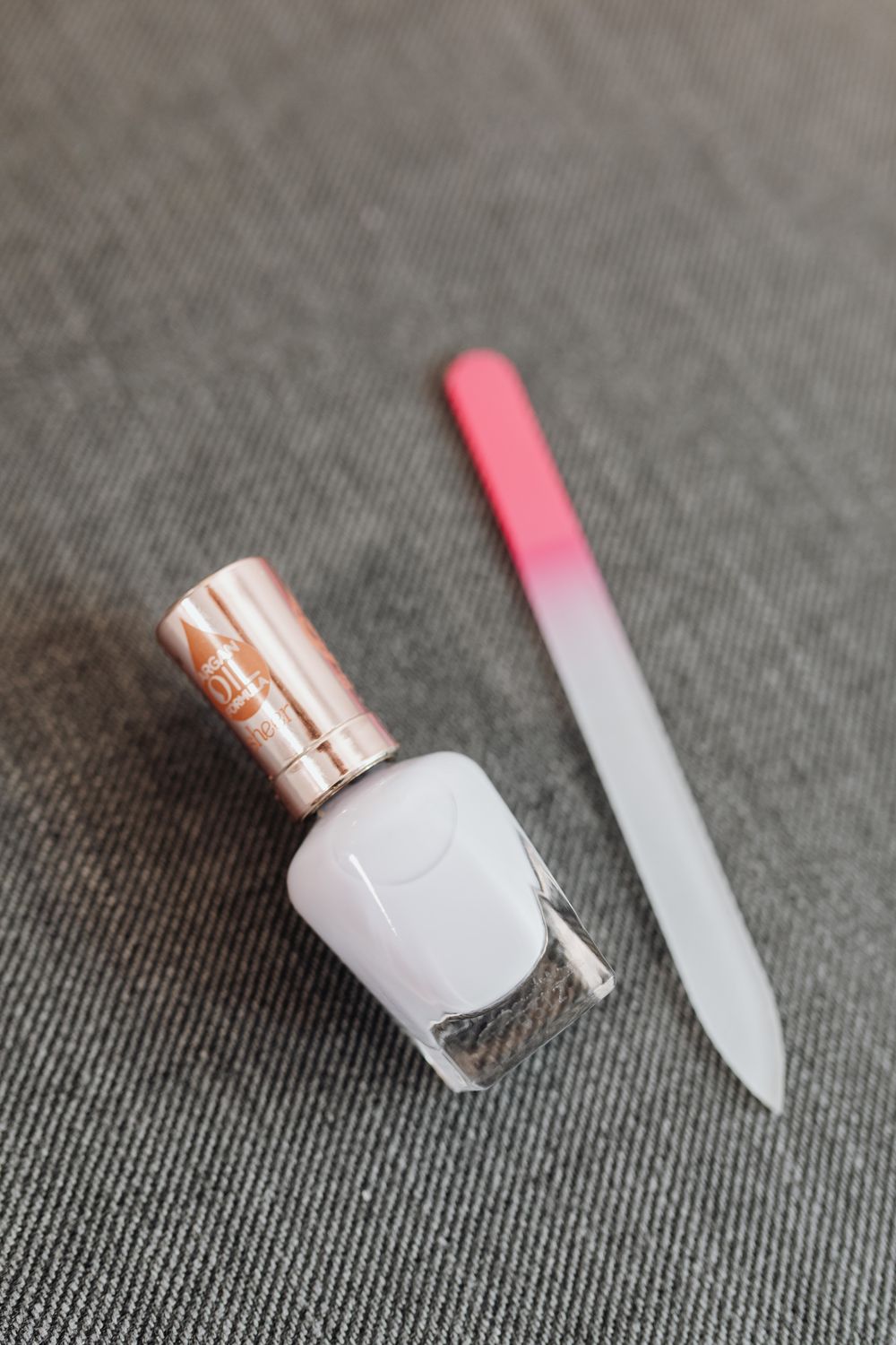 A pale lacquer bottle beside a glass file