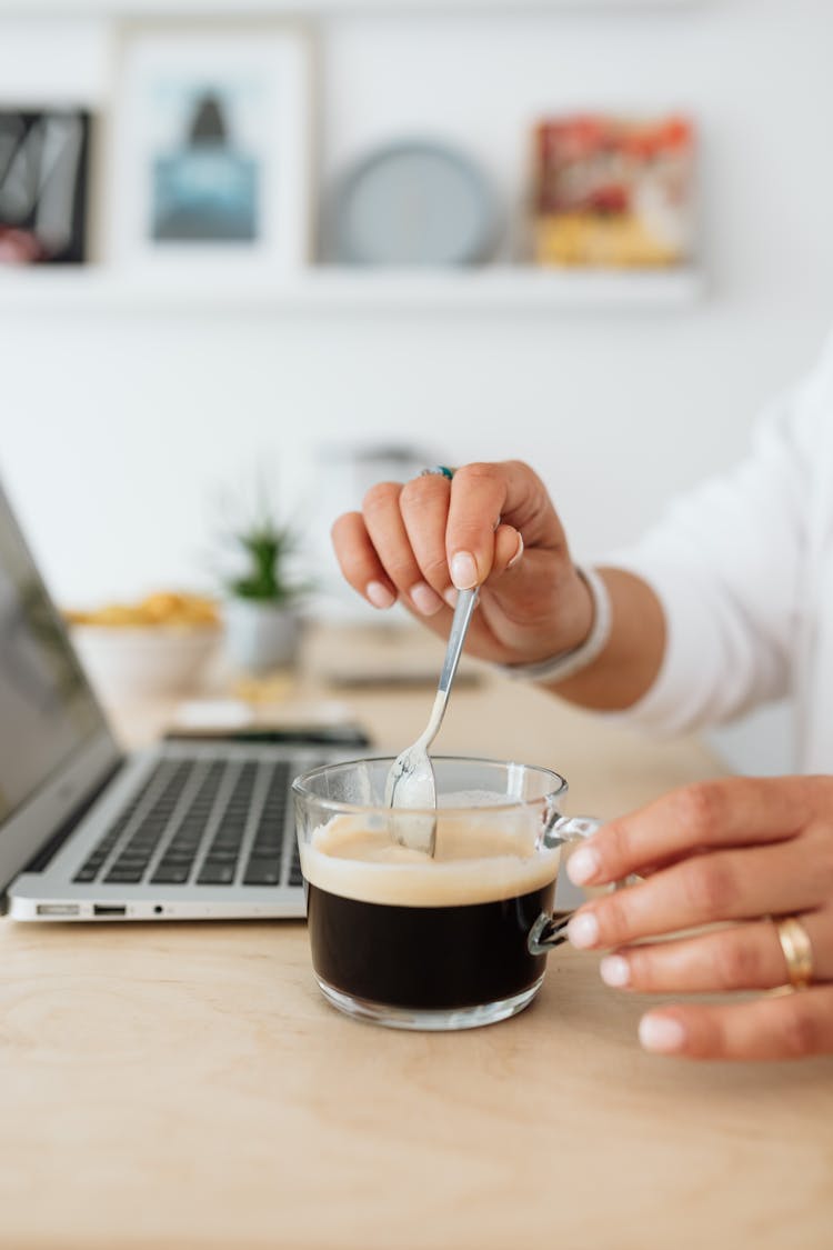 Woman Dipping A Spoon In Espresso 