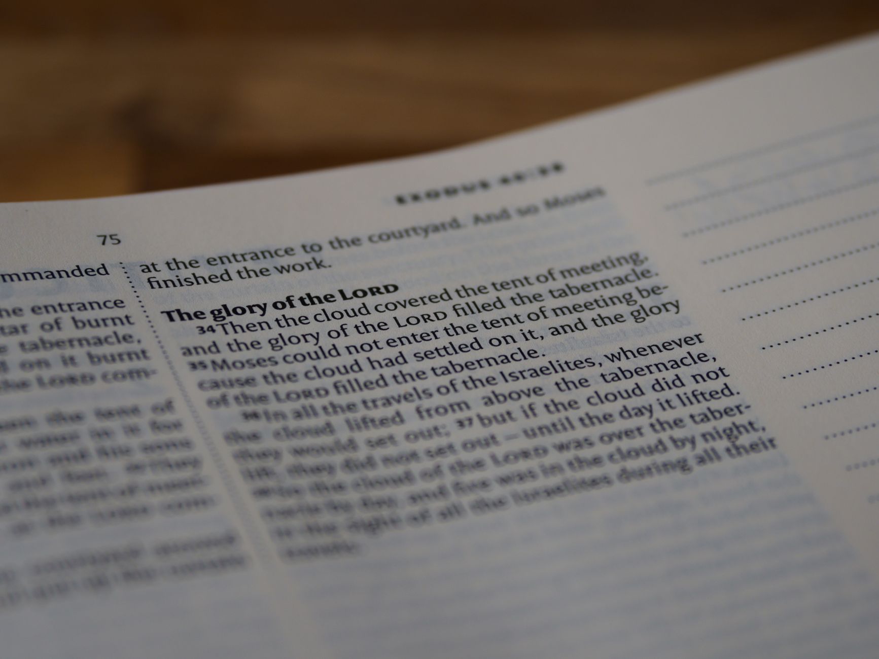 A focused close-up of a Bible page highlighting Exodus 40:34, depicting profound religious themes.