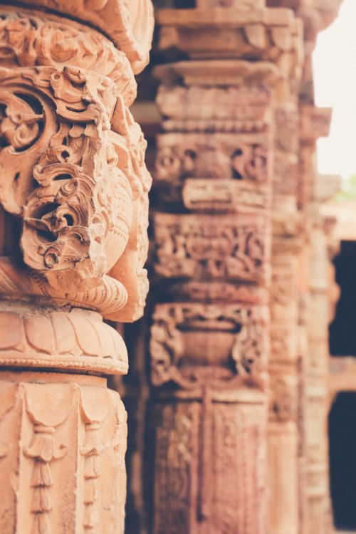 Free Detailed close-up of carved stone columns at Qutb Minar, a historic landmark in New Delhi, India. Stock Photo