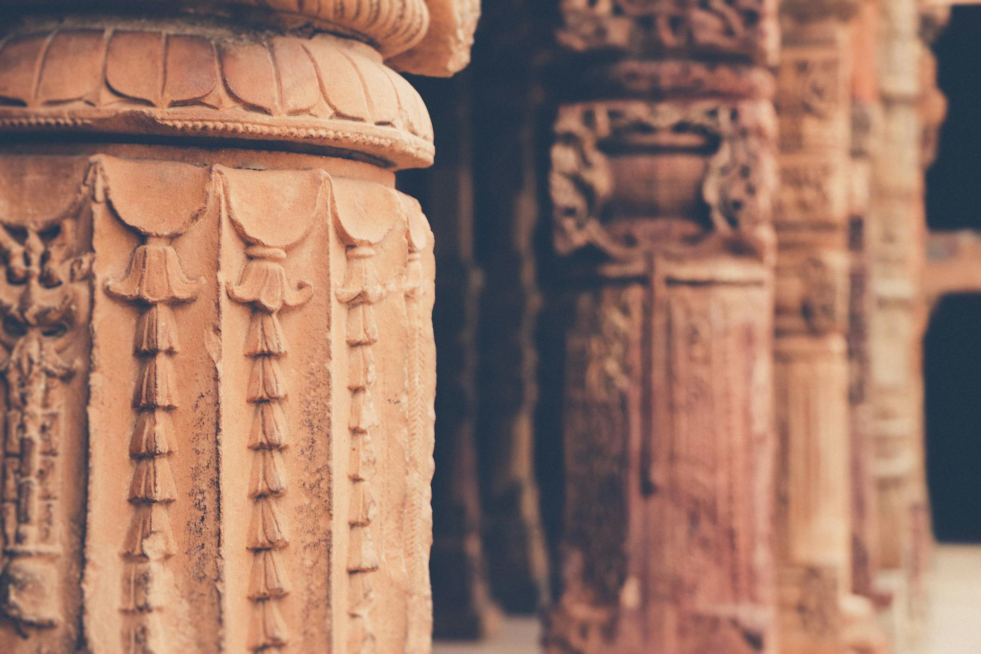 Close-up of detailed stone columns at Qutub Minar in New Delhi, showcasing ancient design and craftsmanship.