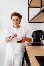Woman in White Long Sleeve Shirt Holding Clear Glass Mug