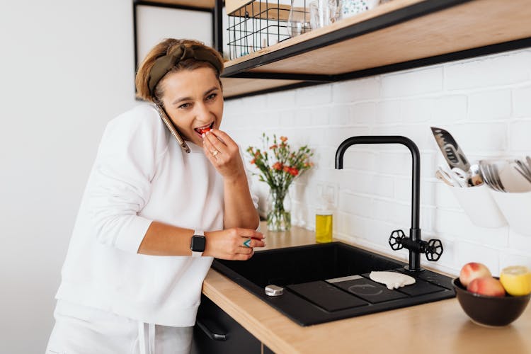 Woman Talking On Phone In Kitchen