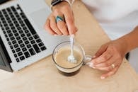 Person Holding a Clear Glass Mug with Coffee