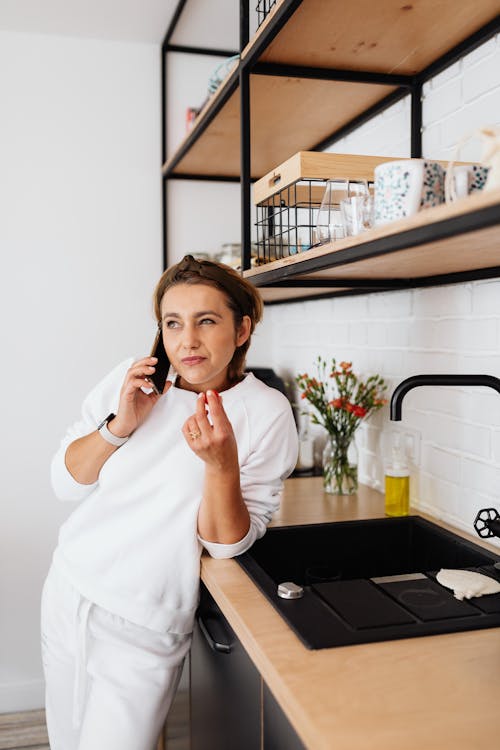 Woman Looking Afar While Holding Her Smartphone on Her Ear