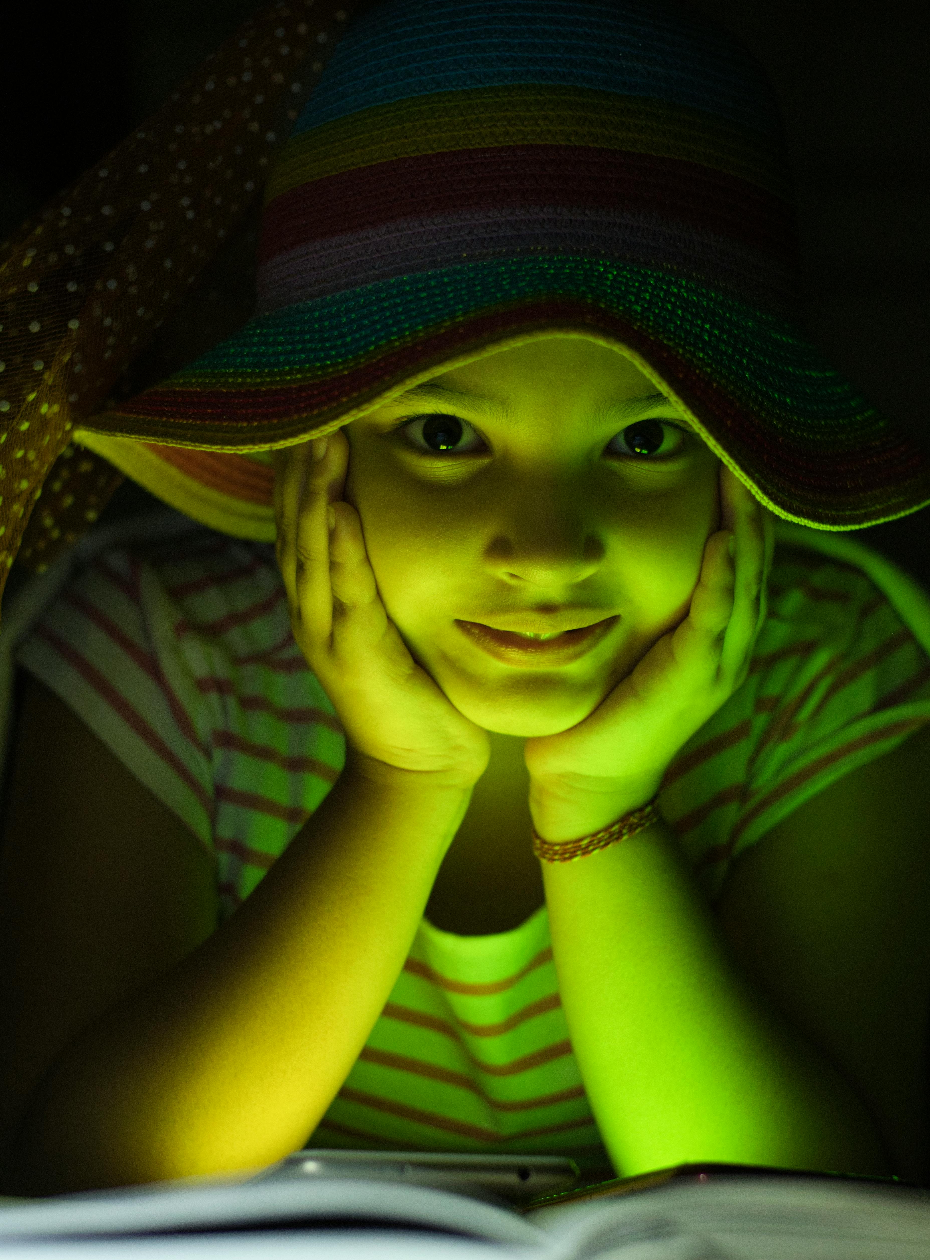 A Cute Girl Lying Down With Her Hands Under Her Chin Free Stock Photo