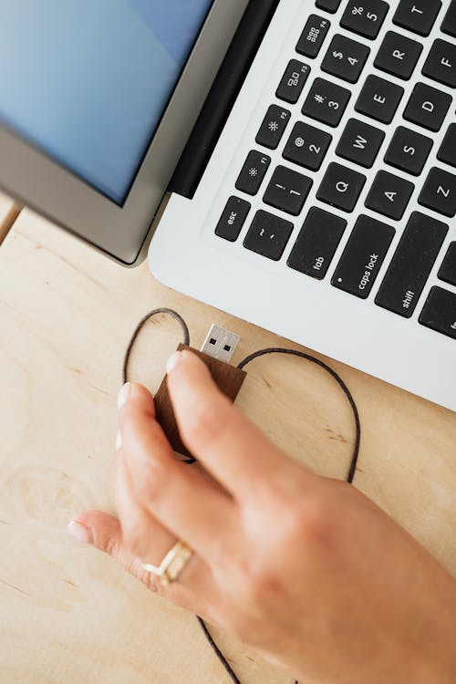 A Person Inserting a Usb into the Laptop · Free Stock Photo