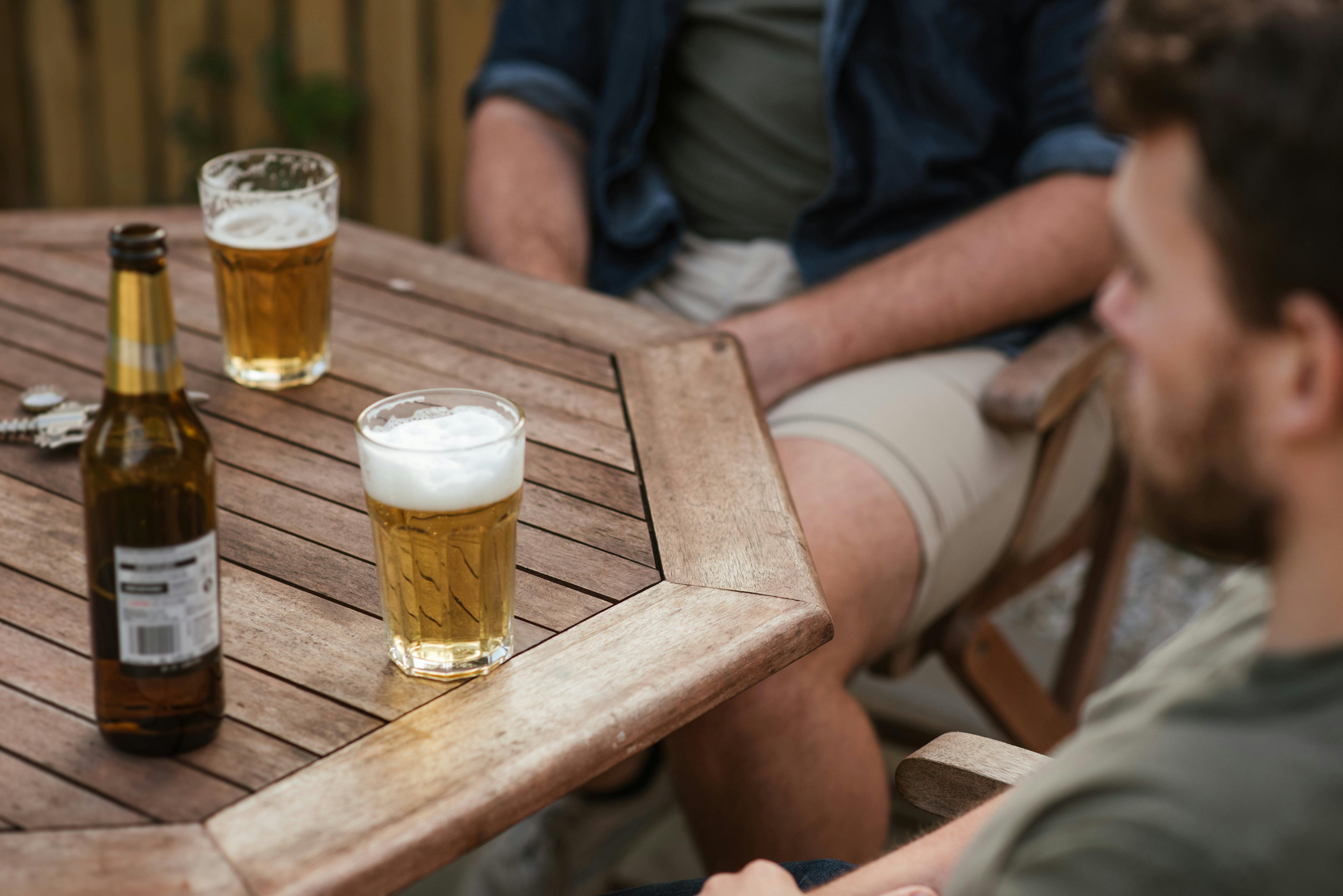 men having beer during picnic in backyard