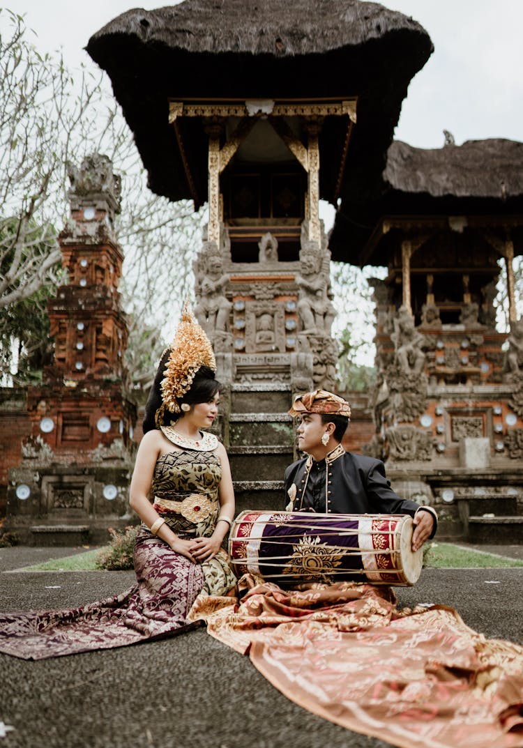 Asian Woman In Flower Wreath Near Boyfriend With Musical Instrument