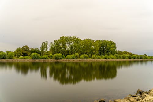 Cloudy Sky Over the Lake Near Green Trees