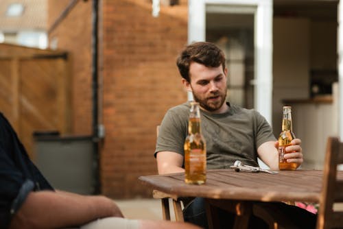 Bearded man having beer with friend