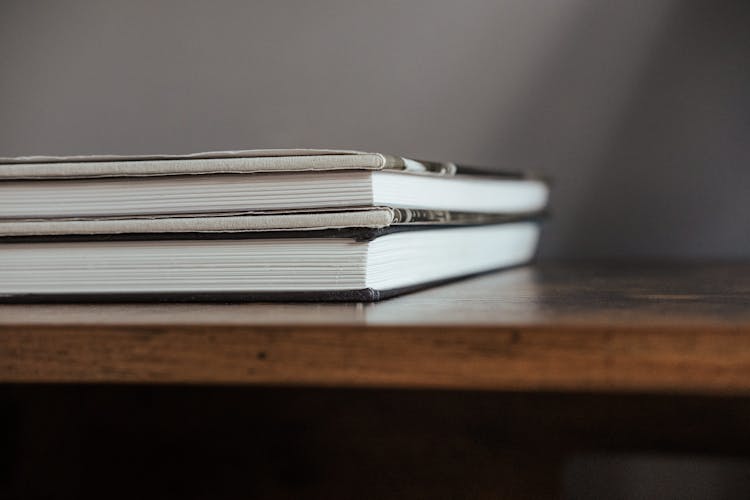 Stack Of Textbooks On Wooden Table