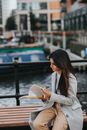 Stylish ethnic woman turning pages of magazine