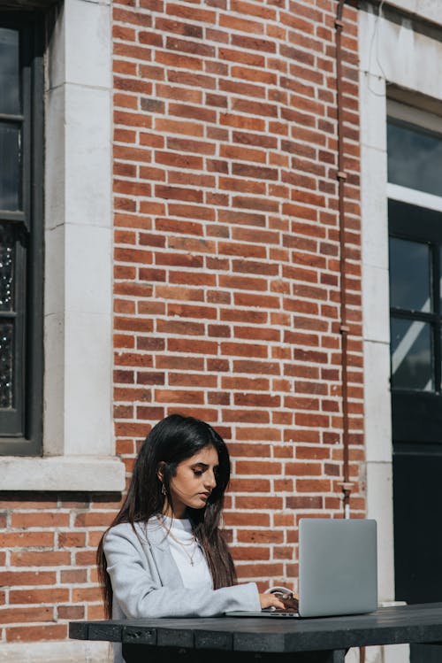 Focused ethnic entrepreneur working on laptop in city