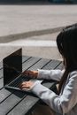 一位女性在户外用笔记本电脑远程工作