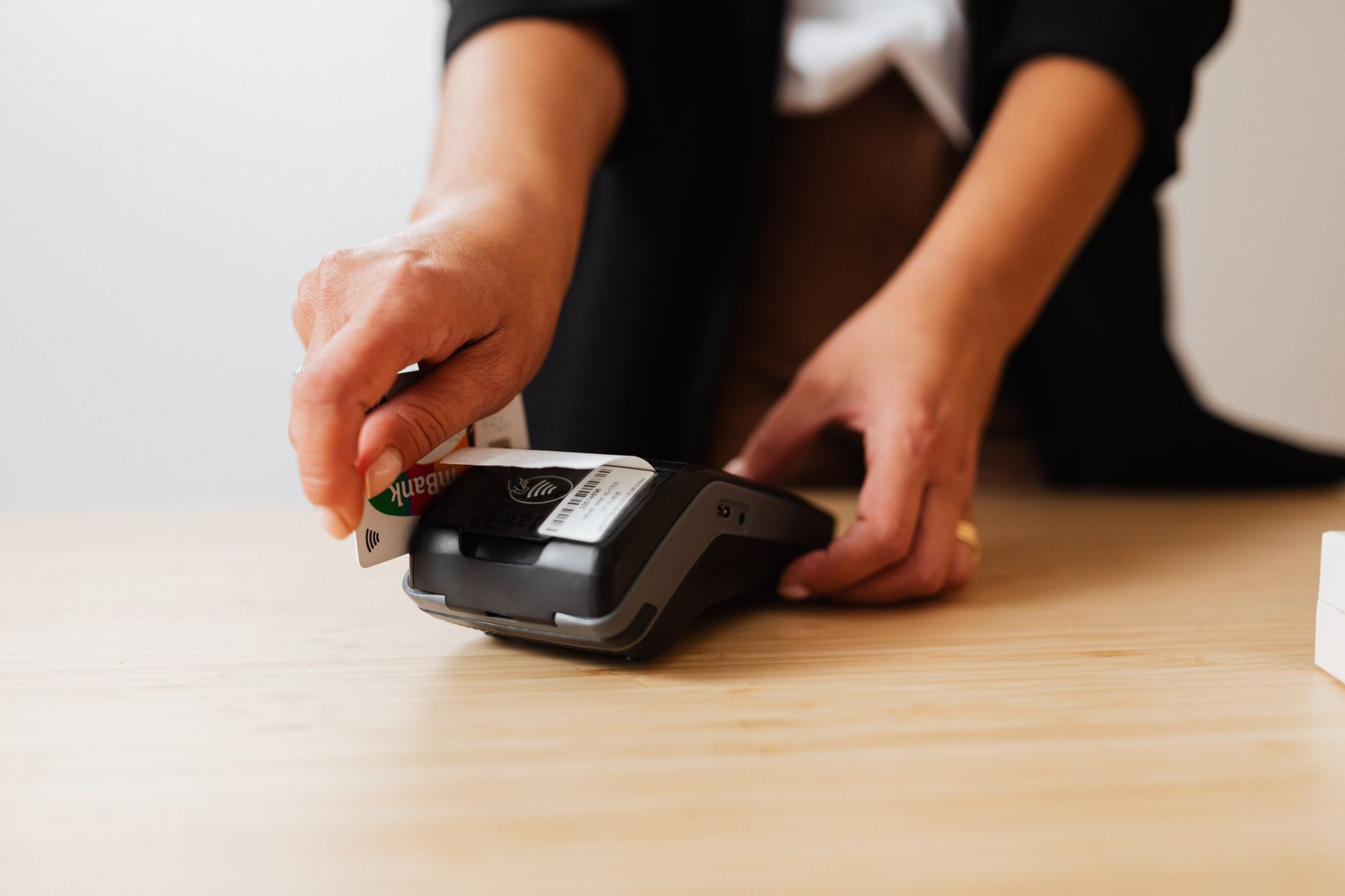 A person makes a cashless payment using a credit card on a payment terminal.
