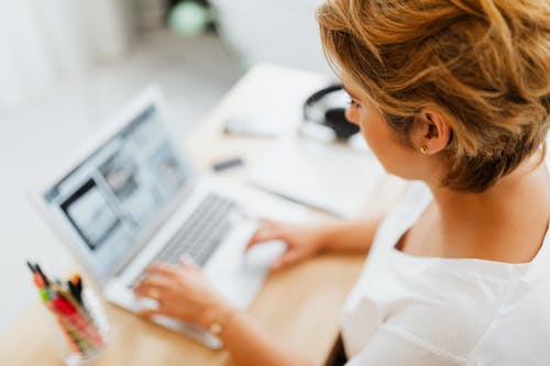 A Woman in White Shirt Using Laptop