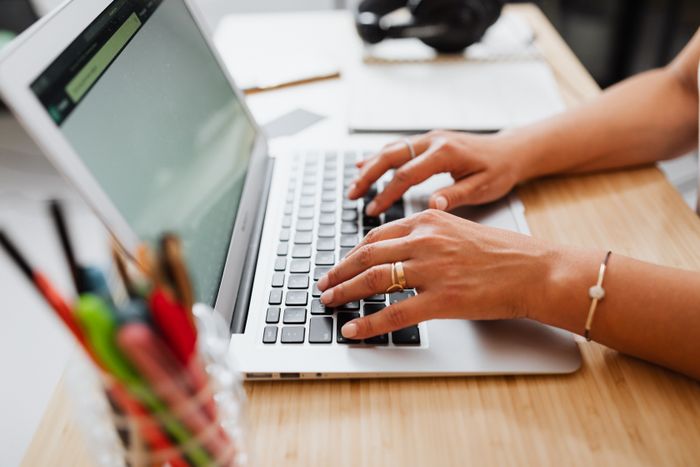 Writer typing on a laptop at a desk