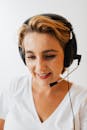 Woman in White Shirt Wearing Black Headphones