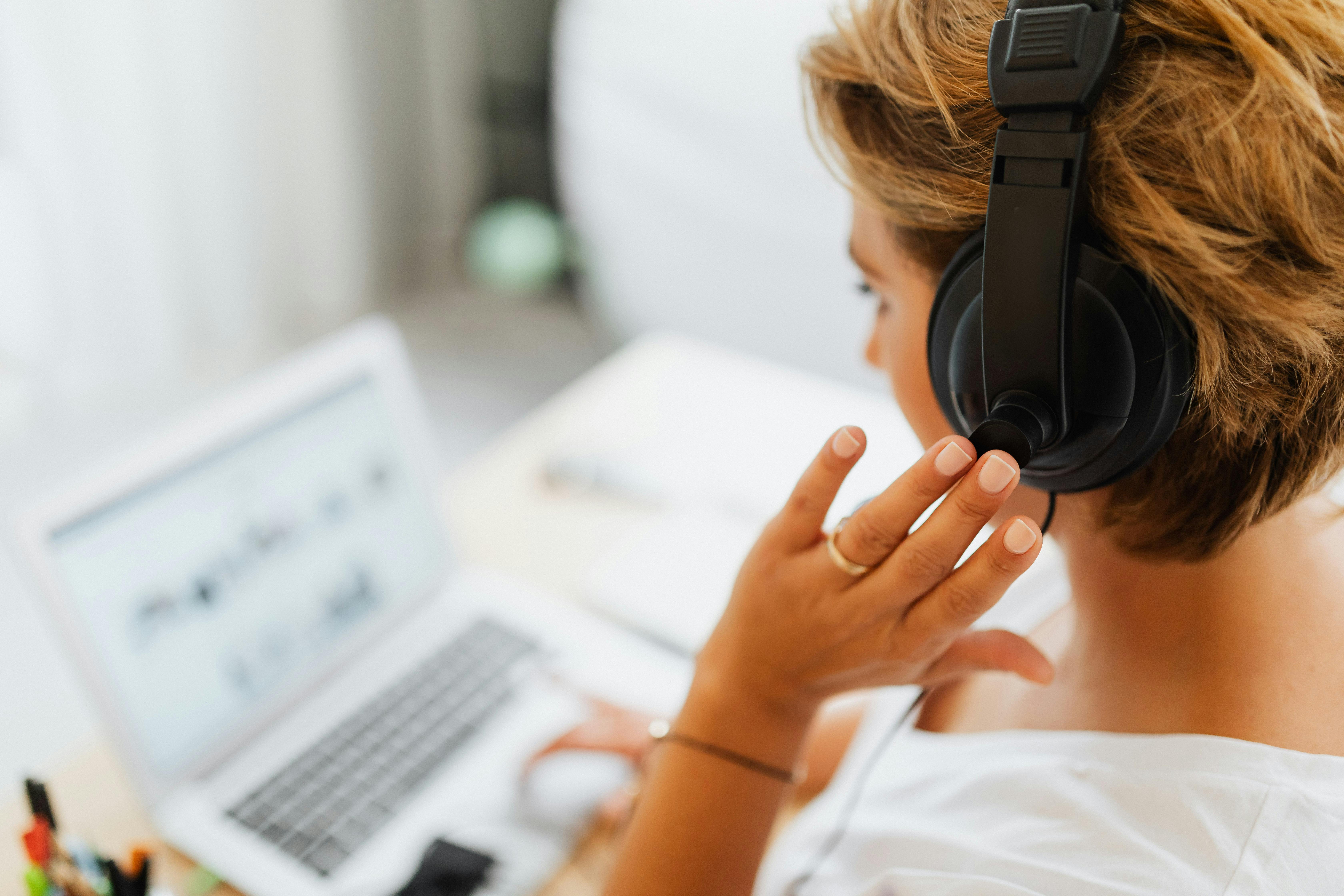 person in white shirt holding black headphones