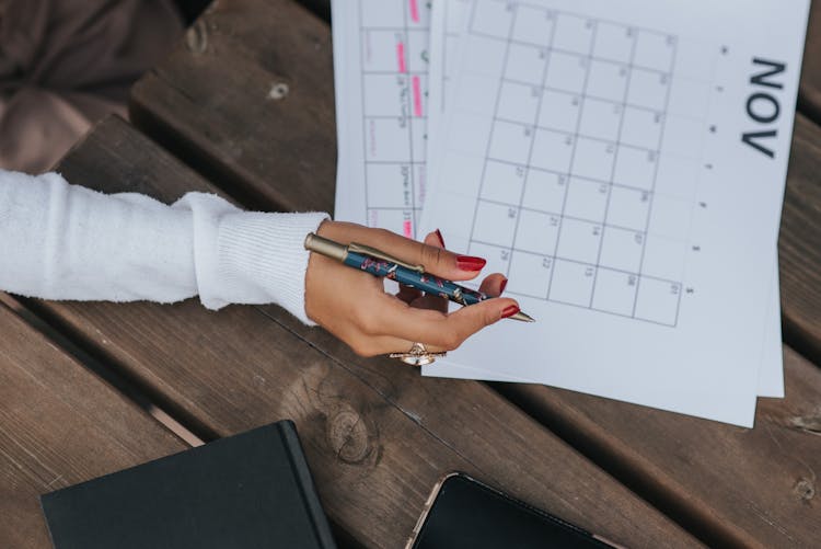 Crop Woman Writing In Calendar