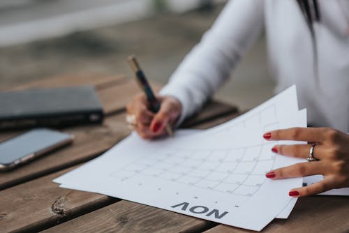 Free Crop woman filling calendar for month Stock Photo