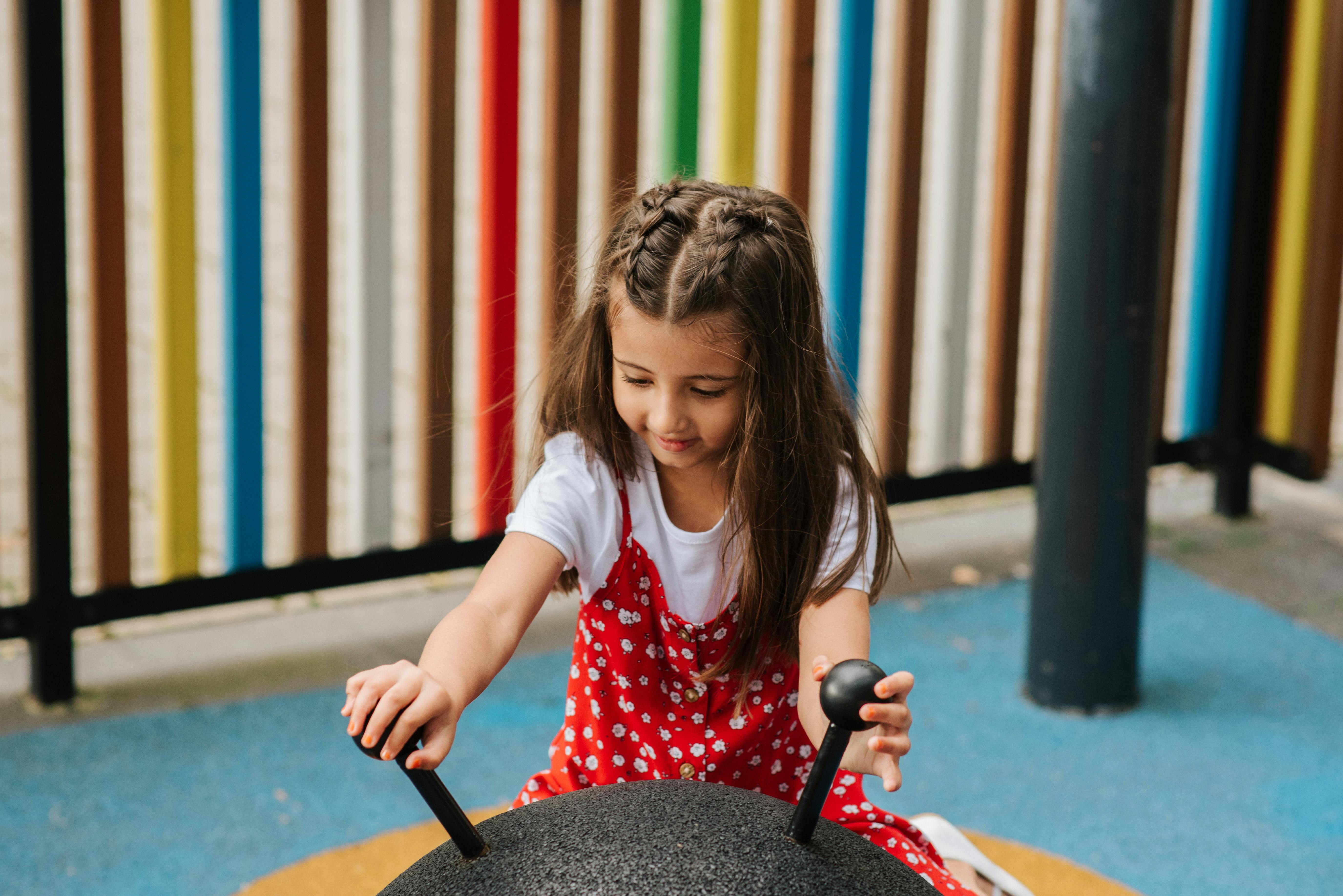 little girl playing on playground on street