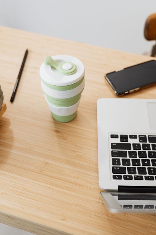 Free High angle view of a desk setup with a coffee cup, laptop, and smartphone for productive work. Stock Photo