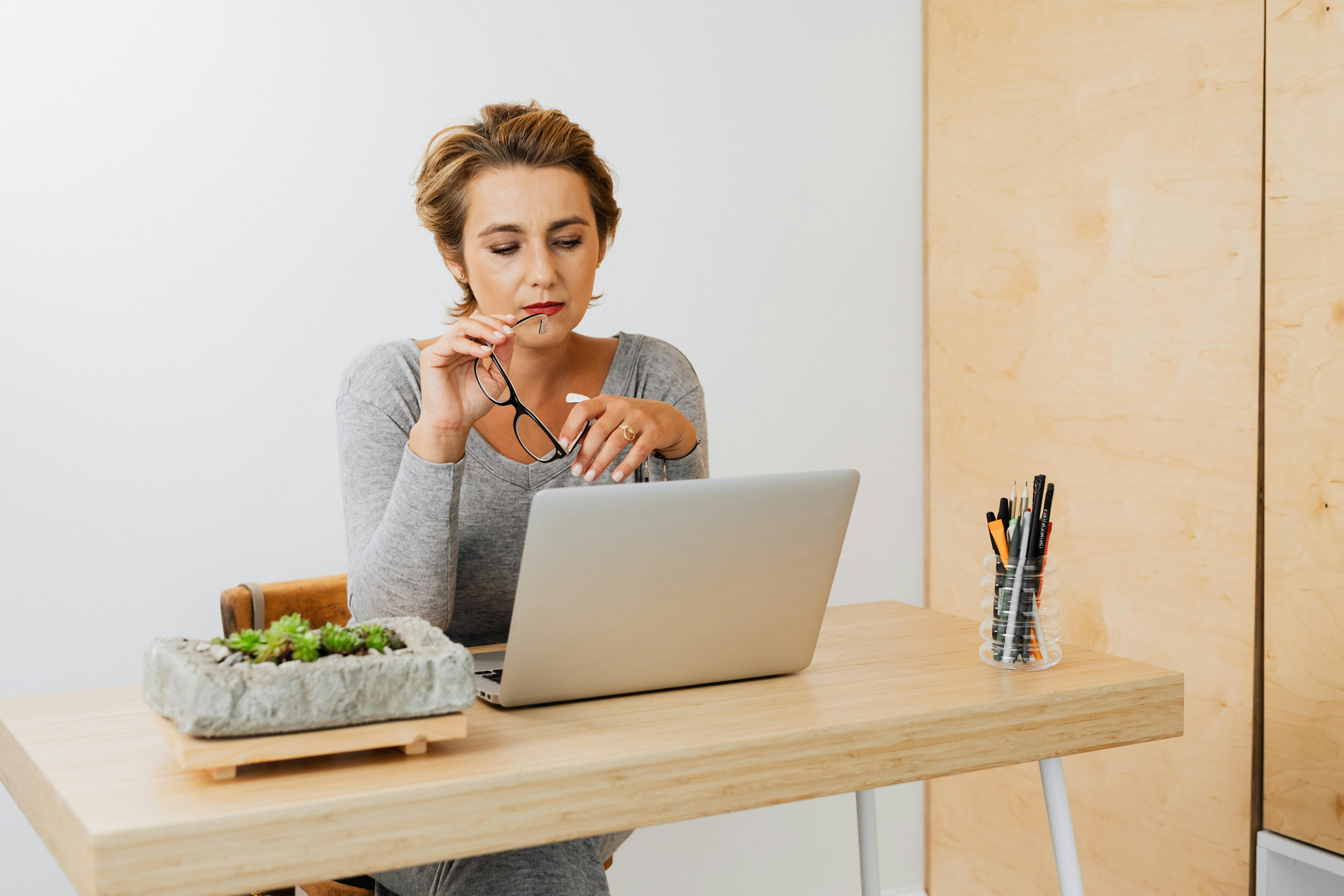 A working life coach reviews her client schedule and revenue from a focused home office.