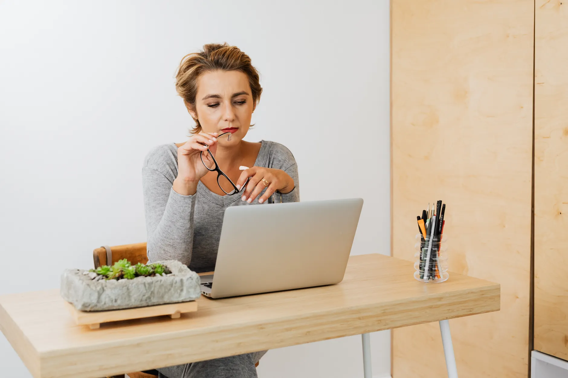 A working life coach reviews her client schedule and revenue from a focused home office.