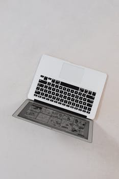 Overhead view of a modern laptop on a white surface, showcasing technology and design.