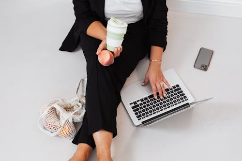 Free A Person Sitting on a Floor Working on Her Laptop Stock Photo