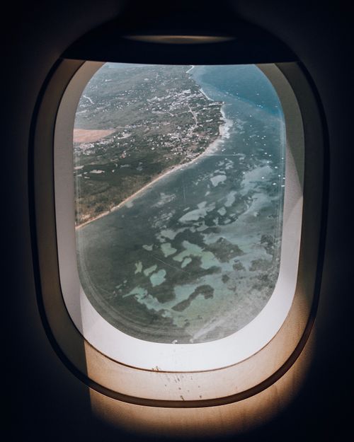 Free A breathtaking aerial view of coastline and landscape from an airplane window during daytime flight. Stock Photo